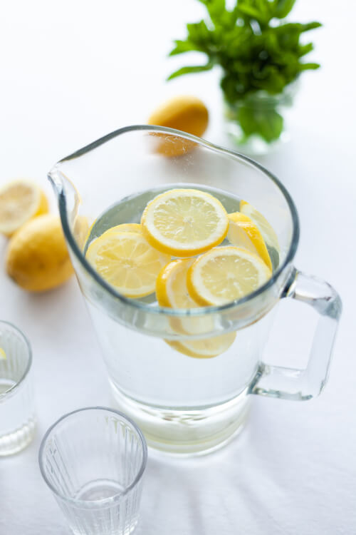 Water jug and glasses with lemon. Photo by Julia Zolotova on Unsplash