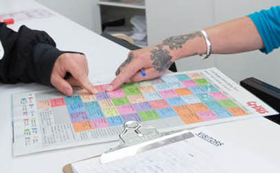 People exploring options on a printed sheet at The Old Firestation Oxford